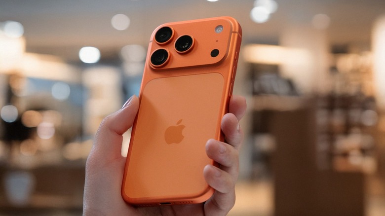Person holding an orange iPhone 17 Pro