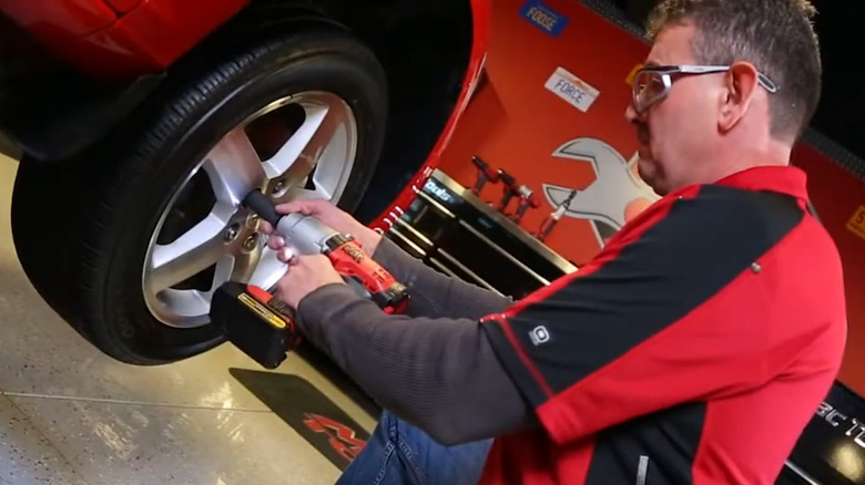 A mechanic using a Mac tool with a DeWalt battery