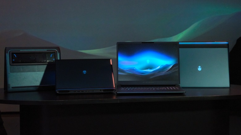 A lineup of four Alienware laptops on a table, each positioned in a different angle.