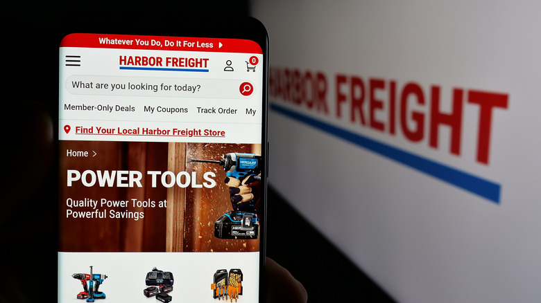 Harbor Freight website pulled up on phone with logo on screen in background