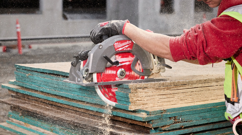 A worker using a saw with a 10-1¼