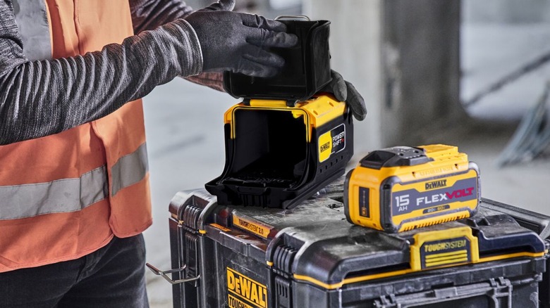 Person installing DeWalt Flexvolt battery into a FlexVolt to Powershift adapter