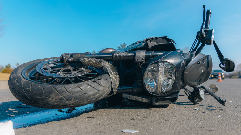 Motorcycle caught in an accident lying on a road.