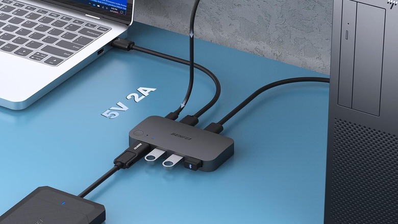 A USB switcher connected to a laptop and a desktop tower.