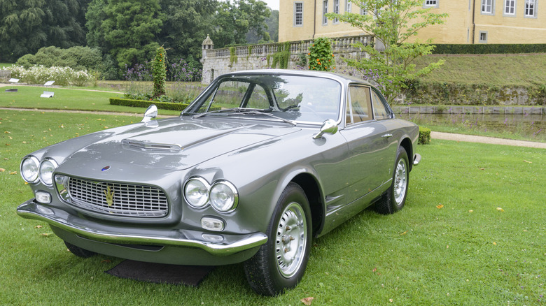 A silver Maserati 3500 Serie I on display at a concours event on a grass lawn.
