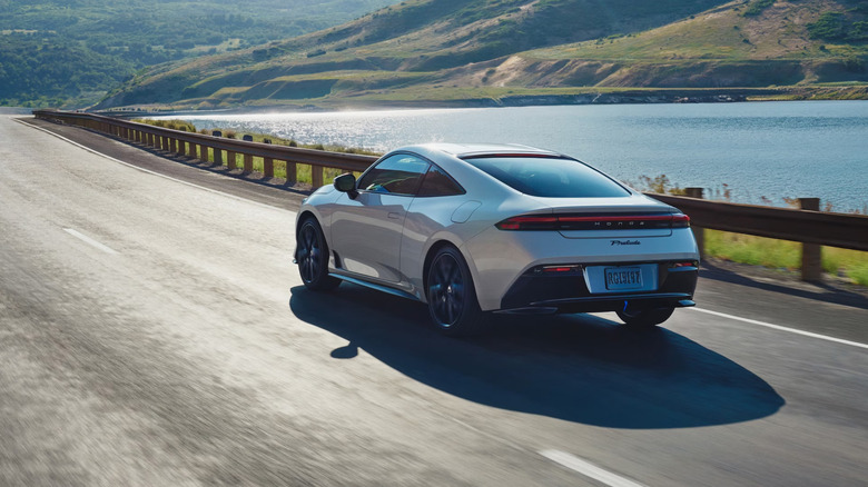 A gray Honda Prelude driving down a lakeside freeway
