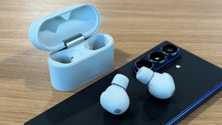 Sony WF-1000XM6 earbuds and a phone on a table