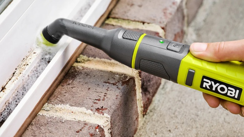 Person using a Ryobi USB Lithium detail scrubber outdoors