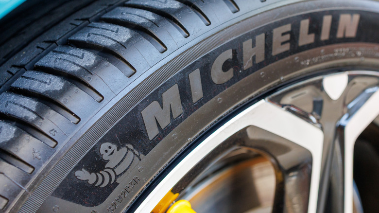Michelin tire on wheel, mounted on a car, showing brand name