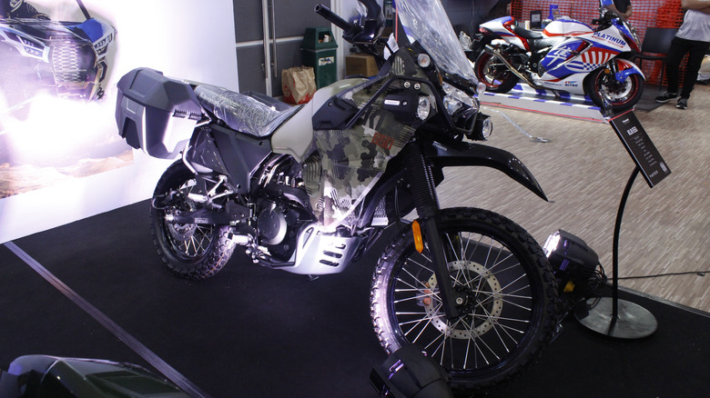 A classic gray and silver Kawasaki KLR650 from an unknown model year on display at a show in the Philippenes.