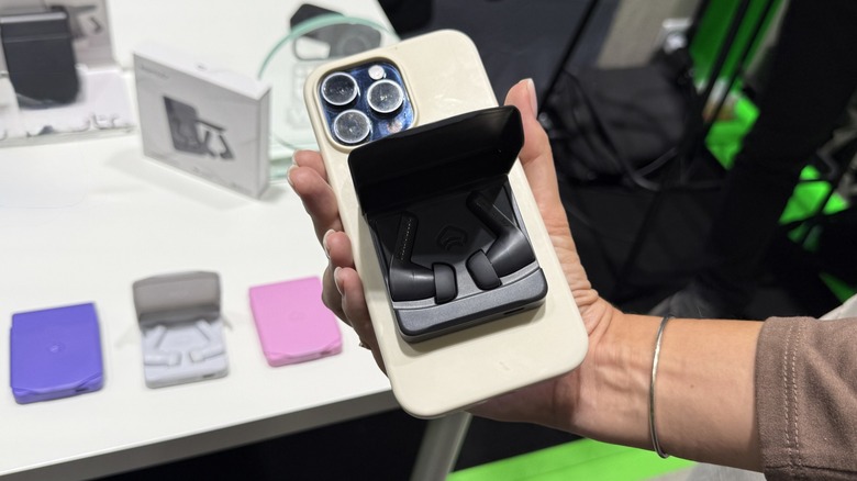 Komutr Artronic Earbuds attached to phone, with other color sets in background