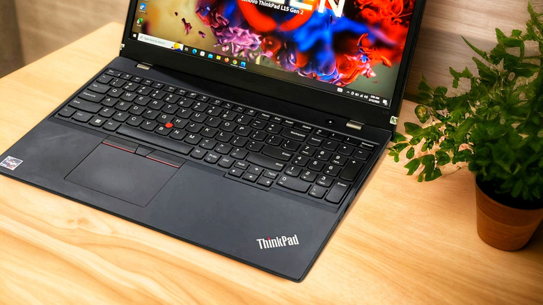 An open Lenovo Thinkpad laptop on a wooden desktop.