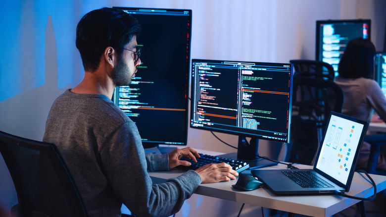 A software developer using multiple monitor setup