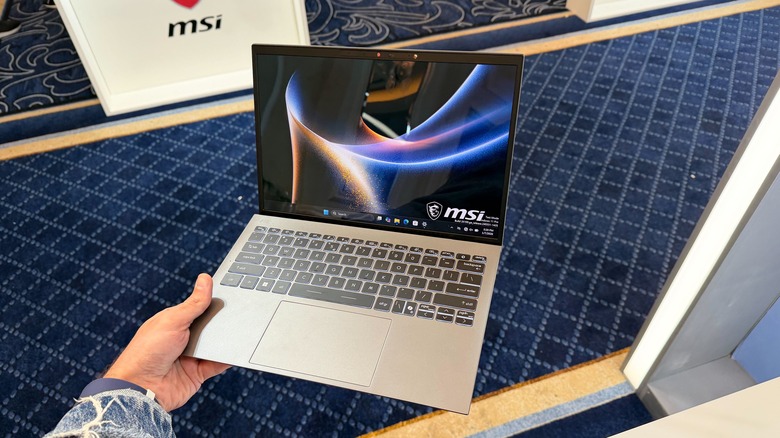 Man holding MSI Prestige 13 AI+