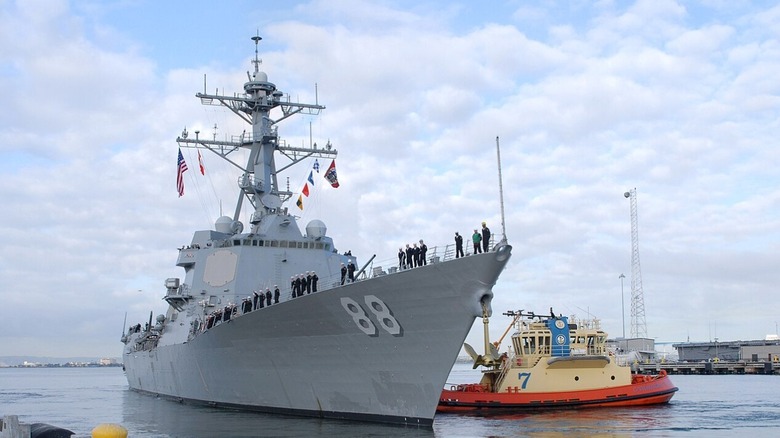 USS Prebble beside a tug boat.