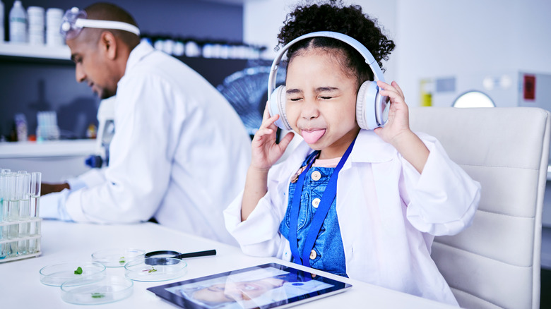 Girl on labcoat listening to music