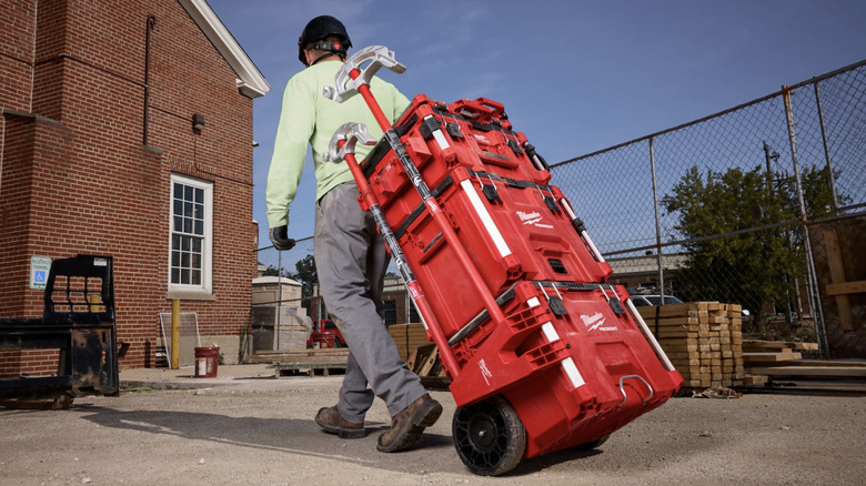 Worker pulling Packout Stack wit Long Tool Holder Attachment and tools