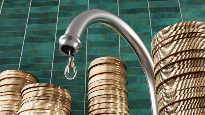 A leaky faucet next to multiple stacks of coins.