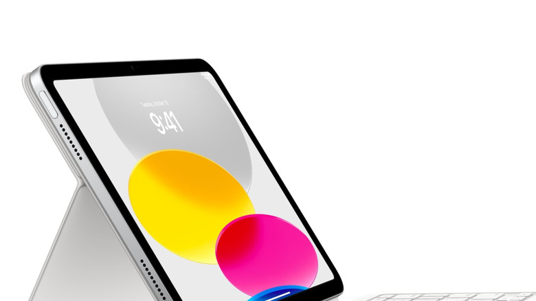 An iPad with the time displayed in front of colorful circles, seen from the side.