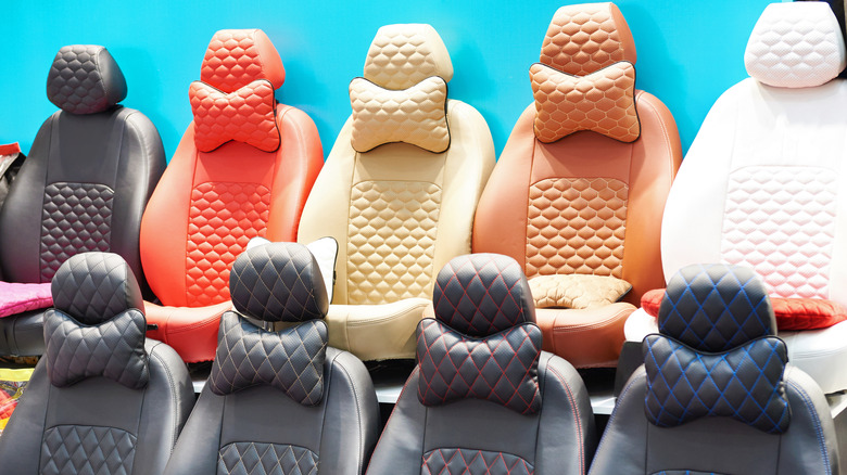 Lineup of car seats draped in different colors of car covers