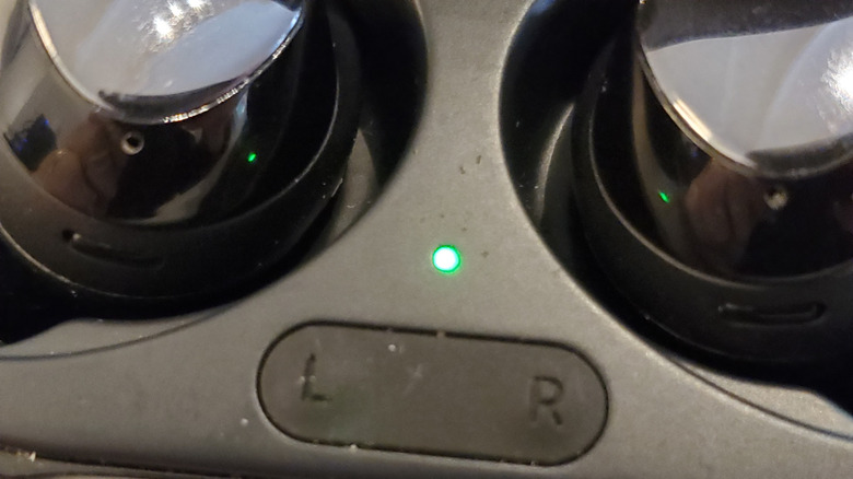 Close up of earbuds case with indicator light in the middle.