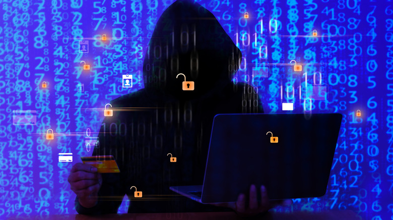 A hacker trying to access credit card information on a laptop