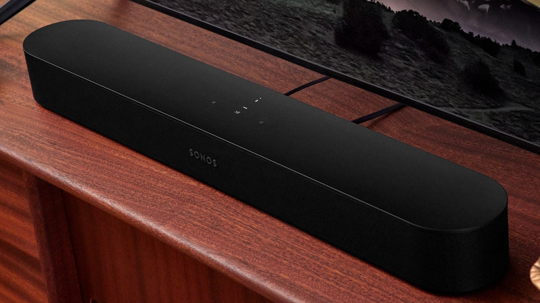 Black Sonos Beam Gen 2 soundbar on a wooden shelf