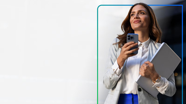 Person holding a phone and laptop