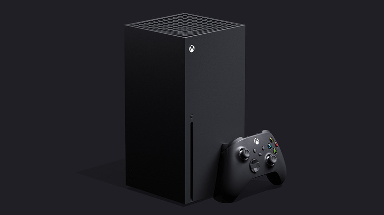 A black Series X console stands vertically next to a matching wireless controller.