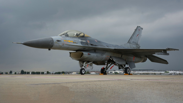 An F-16 parked on the tarmac of an air base.