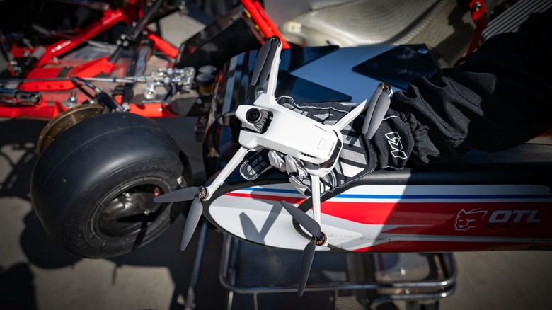 The Antigravity A1 held in a gloved hand in front of a gokart.