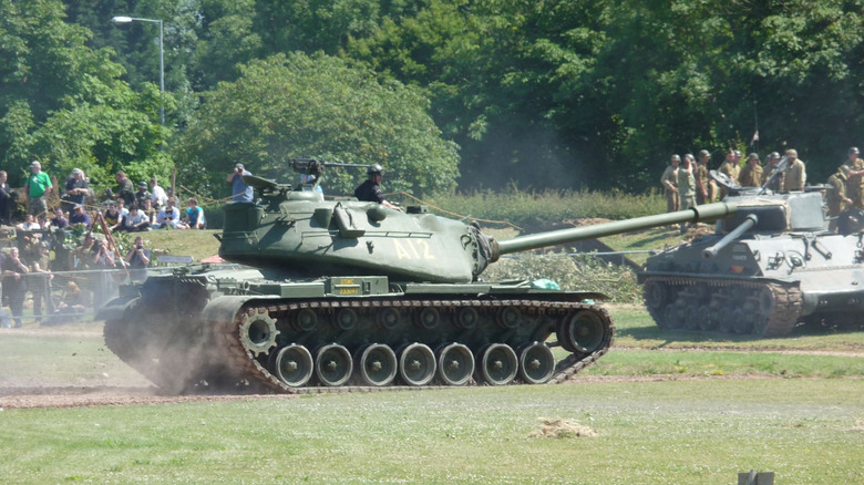 Side view of an M103A2 tank being driven at tank show