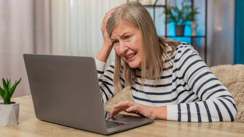 A woman using a laptop with a distressed look