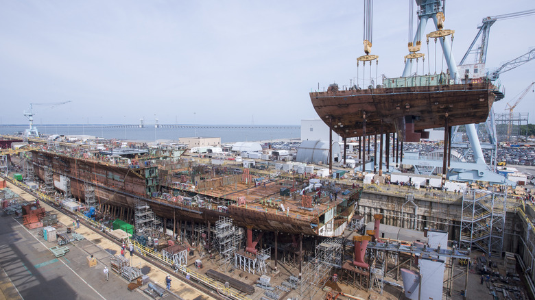 The stern section of the USS John F. Kennedy being lifted into place