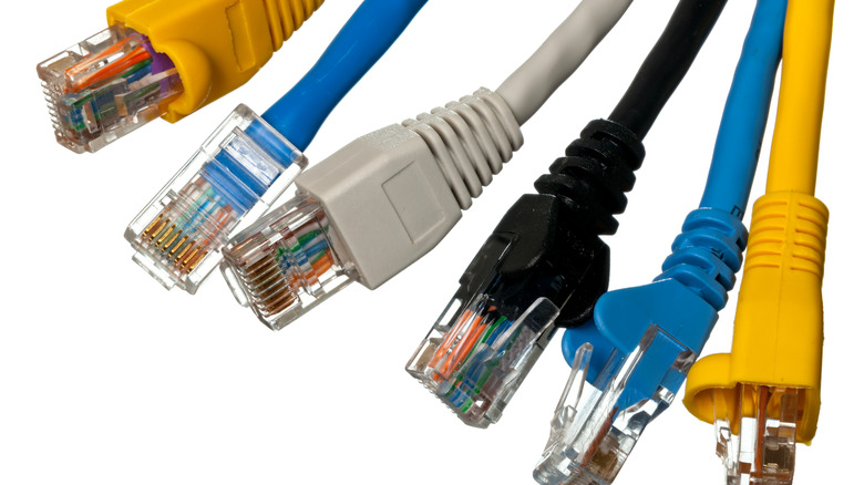 Macro shot of plugs on cat5e cables of many colors isolated against white background