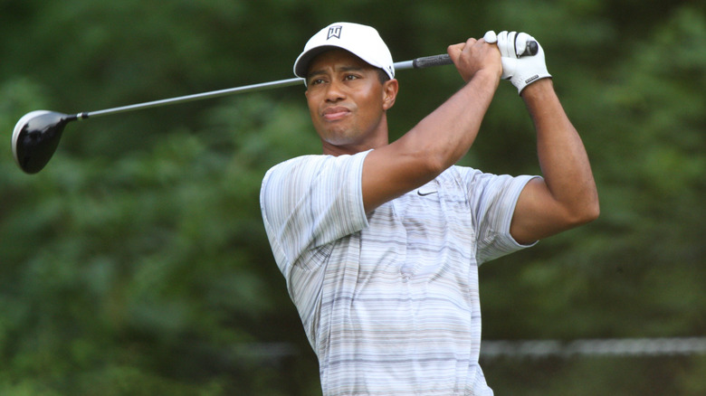 Tiger Woods taking a swing with his gold club