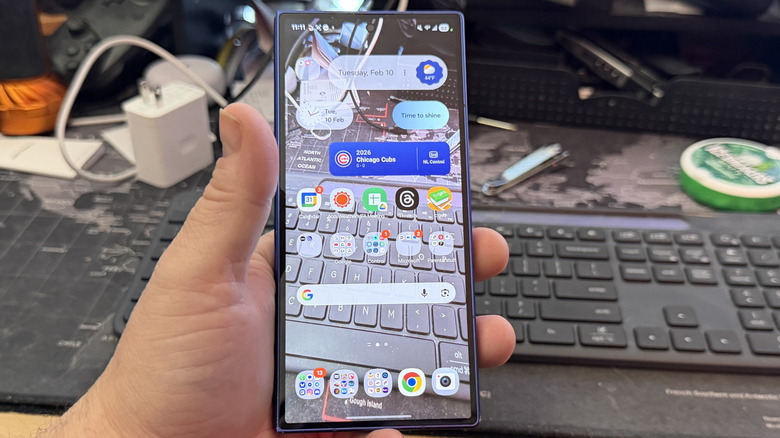 A man holding an Android phone with a transparent wallpaper