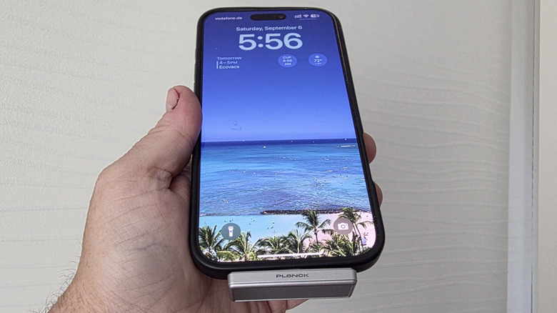 Man holding an iPhone with a Planck