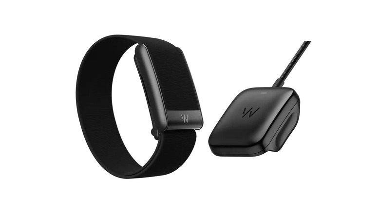 A close up of the Whoop 5.0 and its charging device
