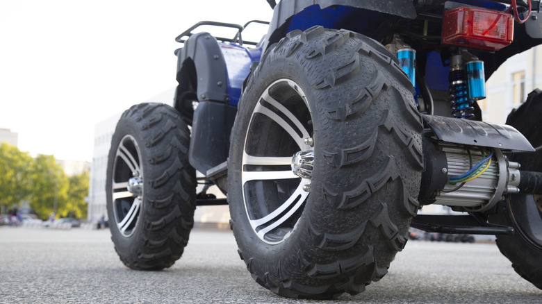 A close up of ATV tires on a paved road
