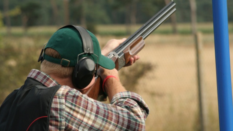 A shooter takes aim at a target with a shotgun