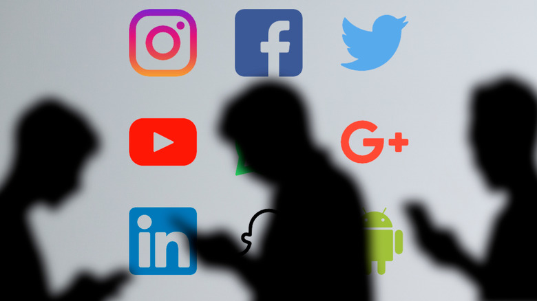 Silhouetted young people with social media logos in background